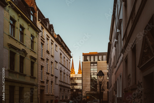 Blick auf Kirche zwischen Häusern bei Sonnenuntergang in Bonn eine Großstadt in Nordrhein-Westfalen
