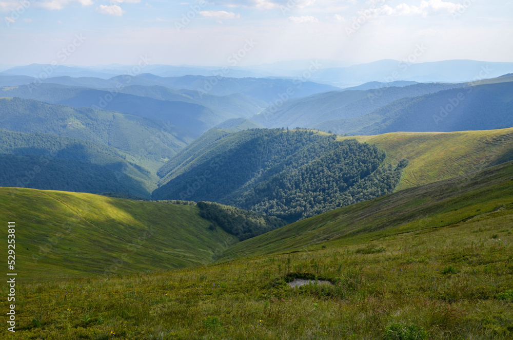 Bright colors of emerald mountain slopes in the light of the sun on a summer day. The concept of outdoor activities and mountain hiking. Borzhava range, Carpathians, Ukraine