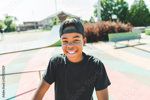 Afro-American boy with black t-shirt posing on a skate park