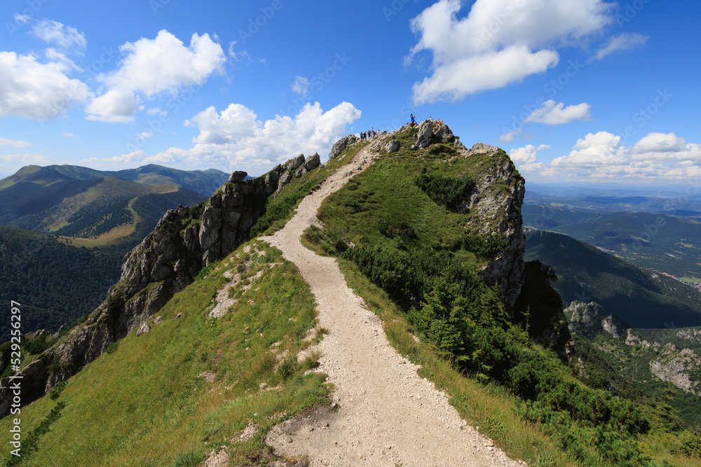 Velky Rozsutec, Mala Fatra, Slovakia. Unidentifiable tourists, hikers and trippers on the rocky top of the mountain and hill. Sunny summer with blue sky. 