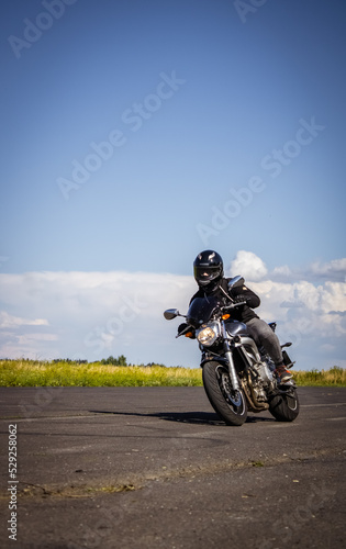 Man riding motorcycle. Motorbike riding on empty road with natural background.