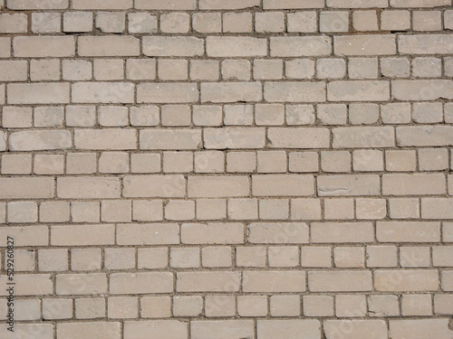 View of empty  white brick wall background with copy space. A deteriorating brick wall outdoors in sunlight