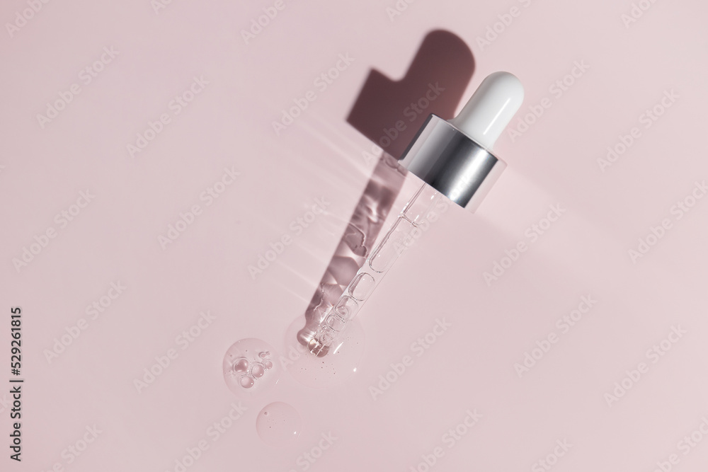 Pipette with dose of fluid hyaluronic acid on pink background. Cosmetics concept. Pipette with dose of fluid hyaluronic acid on pink background. Cosmetics concept.