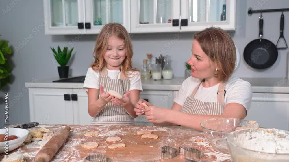 homemade cakes, happy female child together with loving mom spend time together preparing dough cookies on kitchen background