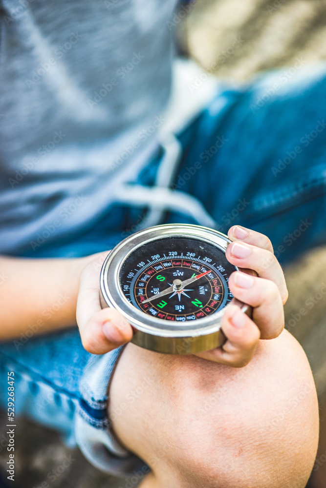 Anonymous boy in the straw hat with compass