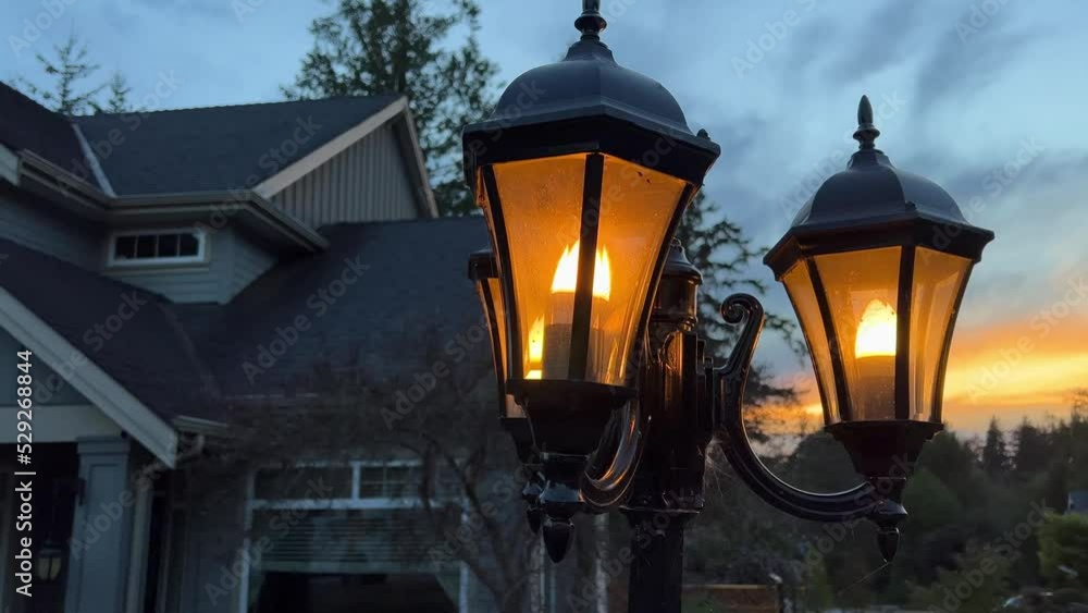 The evening is lit by a lantern near the house, it is just starting to get dark, a private house is located in Canada British Columbia Surrey 09.2022. High quality 4k footage The evening is lit by a lantern near the house, it is just starting to get dark, a private house is located in Canada British Columbia Surrey 09.2022. High quality 4k footage