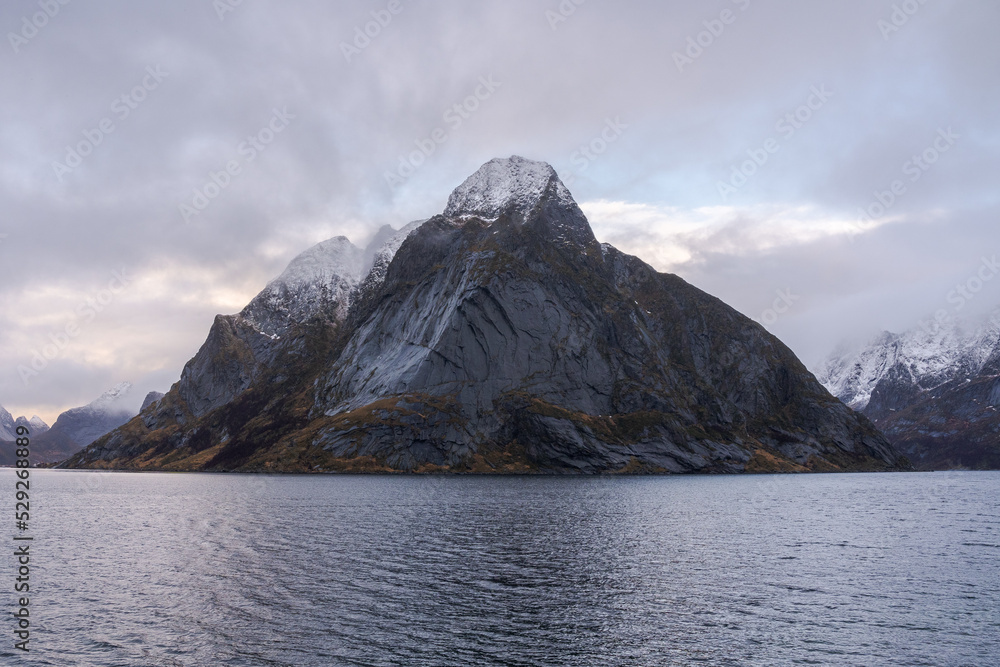 Rocky mountain ridge and wavy sea against gloomy sky in Norway Rocky mountain ridge and wavy sea against gloomy sky in Norway