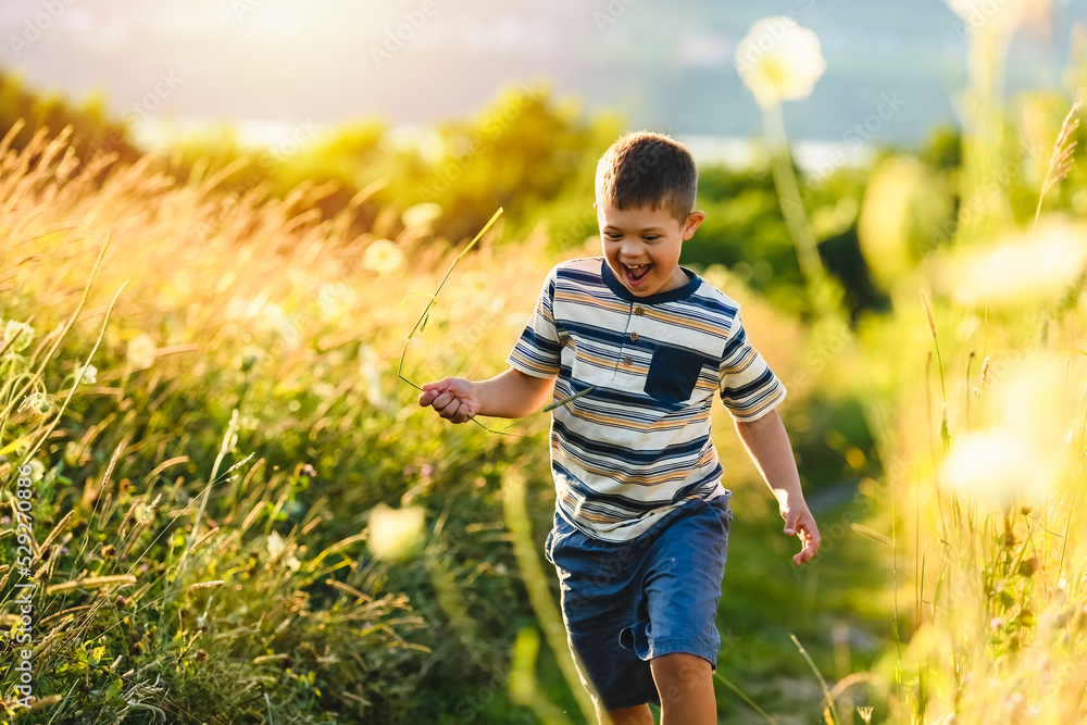 Portrait of a little boy with down syndrome in sunset on summer season Portrait of a little boy with down syndrome in sunset on summer season