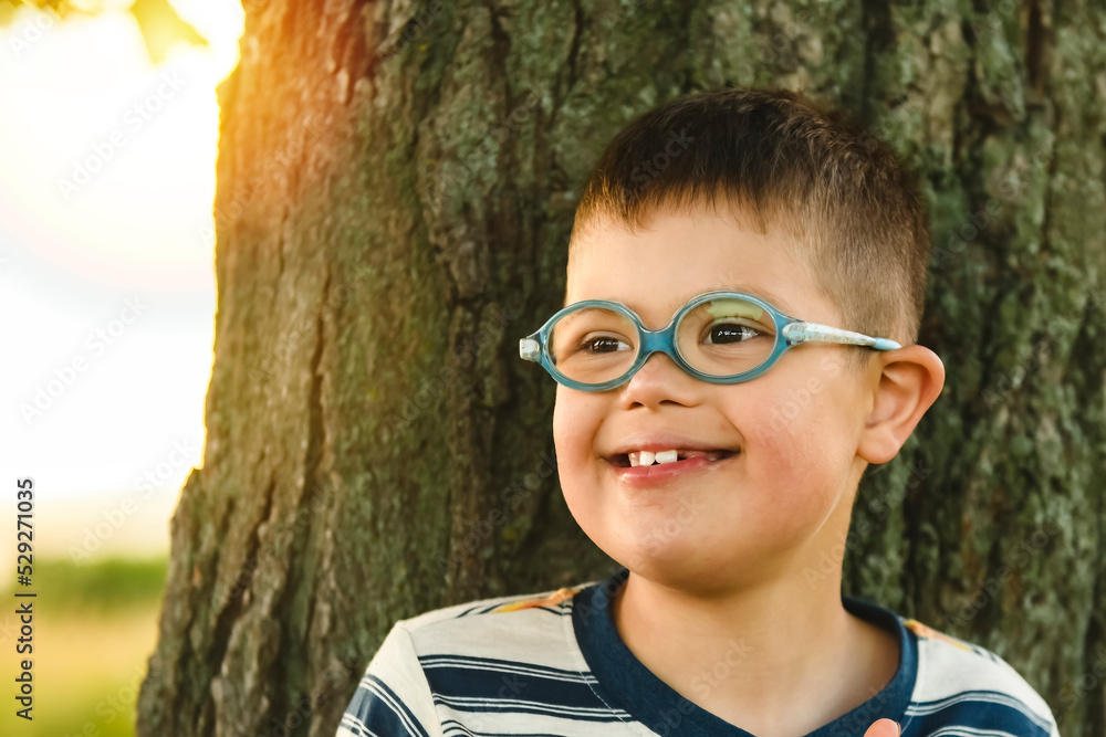Portrait of a little boy with down syndrome in sunset on summer season Portrait of a little boy with down syndrome in sunset on summer season