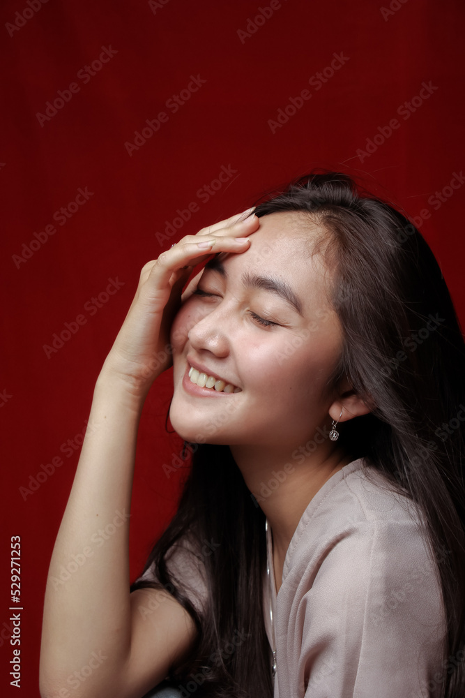 Obraz premium Asian woman taking photo on a red background. Happy Asian woman. Beautiful asian woman with long and straight hair.