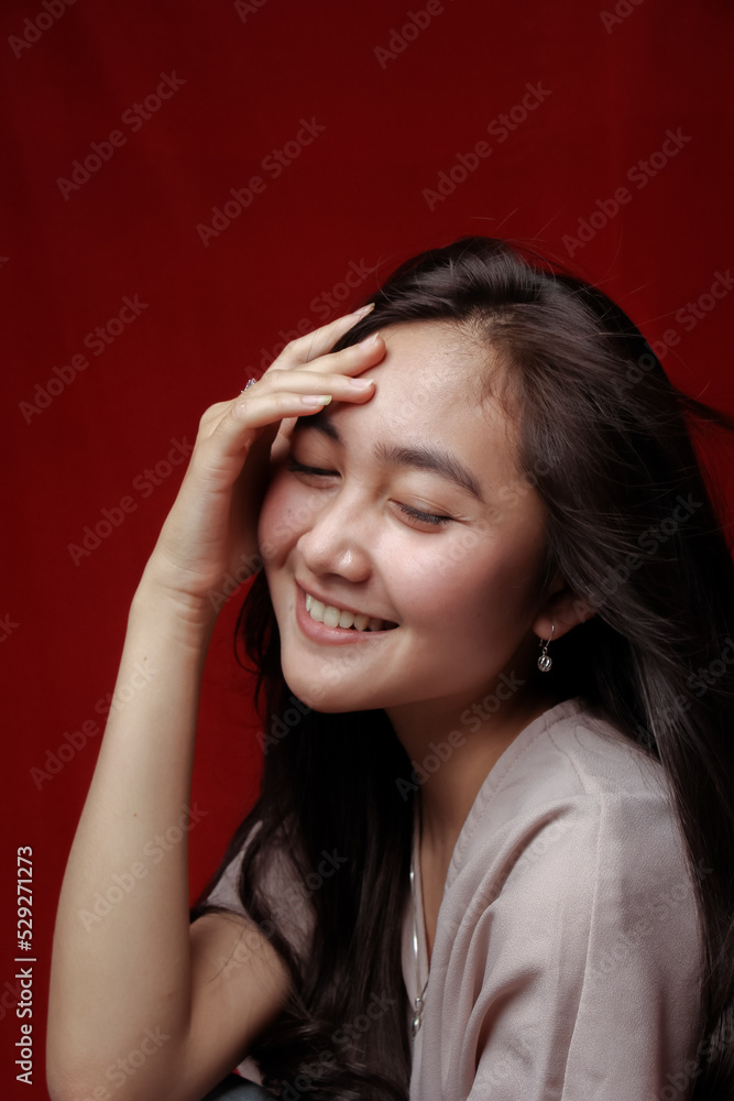 Naklejka premium Asian woman taking photo on a red background. Happy Asian woman. Beautiful asian woman with long and straight hair.