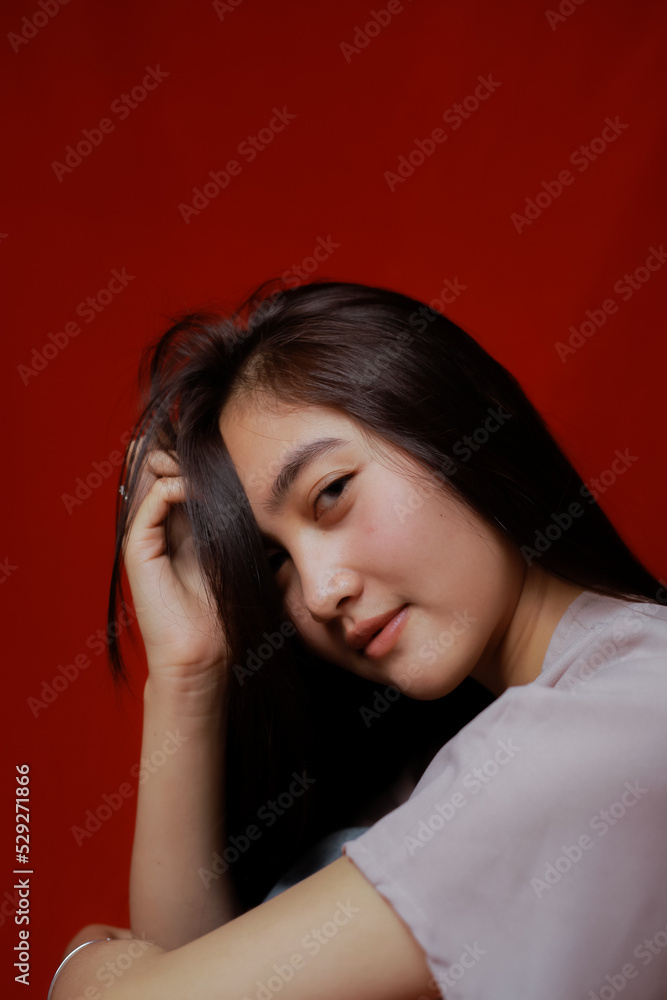 Asian woman taking photo on a red background. Happy Asian woman. Beautiful asian woman with long and straight hair. Asian woman taking photo on a red background. Happy Asian woman. Beautiful asian woman with long and straight hair.
