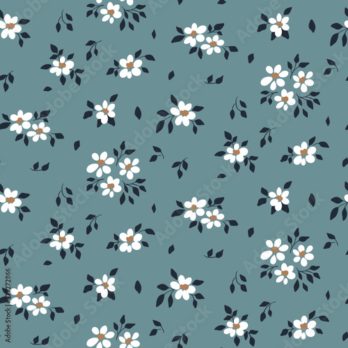 Seamless floral pattern, romantic ditsy print with small white flowers on a blue surface. Pretty botanical background design with tiny drawing plants: flowers, leaves. Vector illustration.