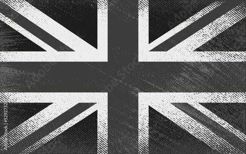 a monochrom full frame image of an old stained dirty union jack british flag with dark crumpled edges.black british flag. vector design grungy textured black britain flag.