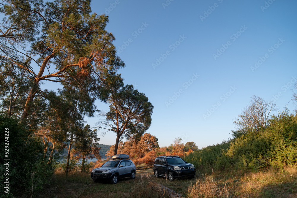 Adventures Camping tourism suv off road cars. Background lake, river an mountains. Landscape outdoor in morning, summer day. Roof rack box. Tourism and vacation. Ukraine. Adventures Camping tourism suv off road cars. Background lake, river an mountains. Landscape outdoor in morning, summer day. Roof rack box. Tourism and vacation. Ukraine.