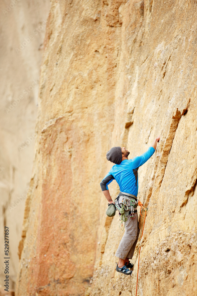 Male climber looking up while climbing mountain Male climber looking up while climbing mountain