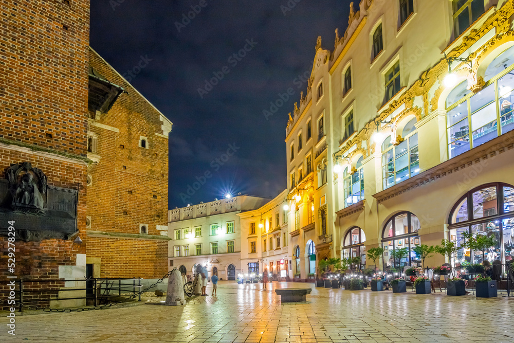 Krakow city in the evening in Poland, Main Square in the Old Town, illuminated St. Mary Church and Cloth Hall (Sukiennice).