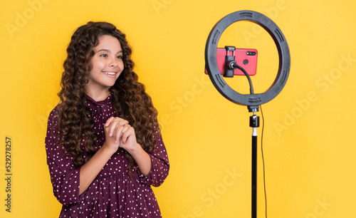 glad child with long curly hair making video for blog