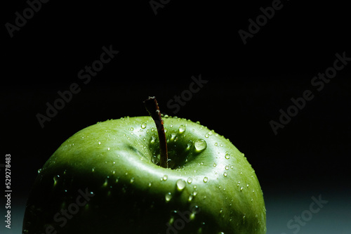 Close-up of wet green apple against black background