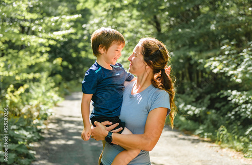 sporty family mothe and son outside in forest photo