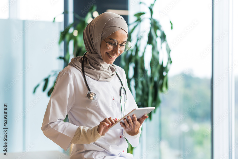 Female doctor in hijab works in modern clinic office, Muslim female doctor  uses tablet computer, nurse in medical white coat and glasses with  stethoscope. Stock-Foto | Adobe Stock