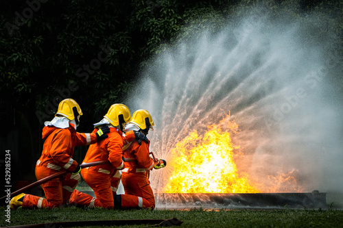 Firefighter Concept. Fireman using water and extinguisher to fighting with fire flame. firefighters fighting a fire with a hose and water during a firefighting training exercise