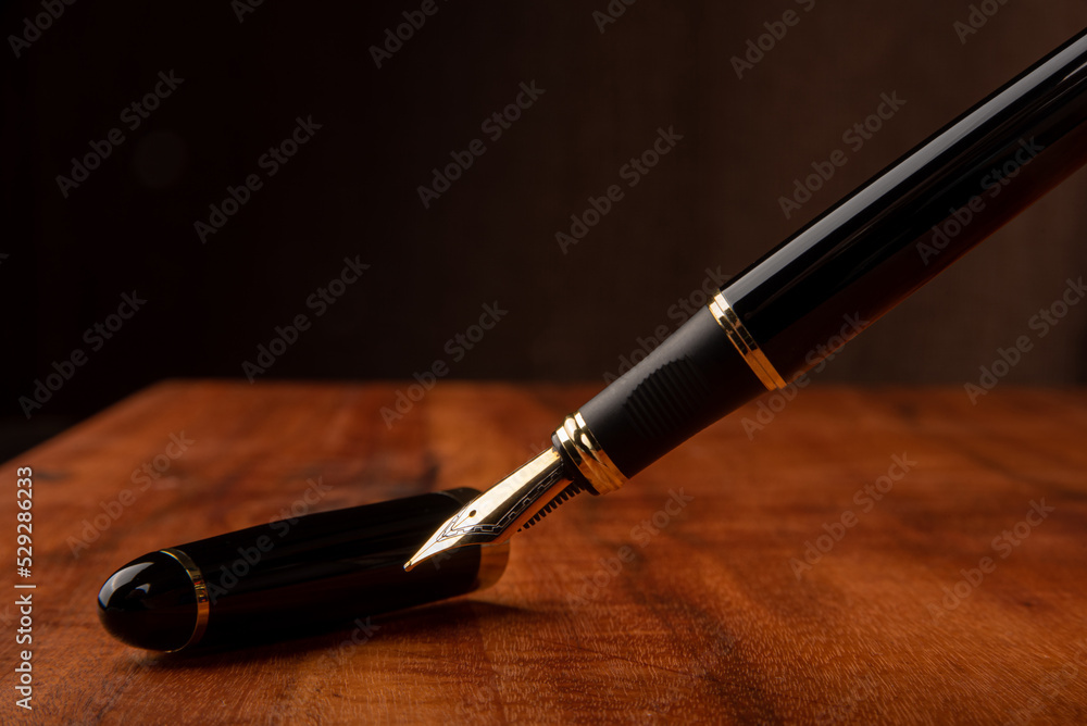 Fountain pen, a beautiful fountain pen on a rustic wooden surface, selective focus. Fountain pen, a beautiful fountain pen on a rustic wooden surface, selective focus.