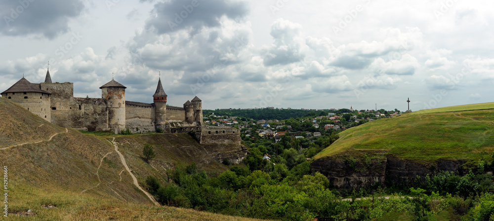 Canyon with Kamianets-Podilskyi castle on one side and iron cross on another in Kamianets-Podilskyi Ukraine Canyon with Kamianets-Podilskyi castle on one side and iron cross on another in Kamianets-Podilskyi Ukraine