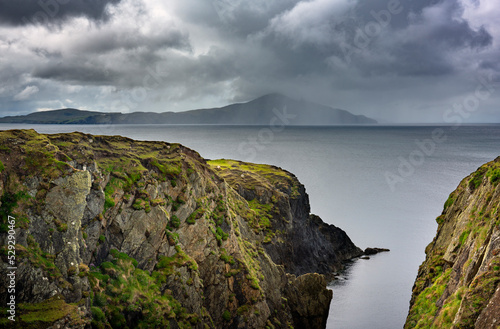Cliffs on the west coast of Achill Island. It is a popular route along the Wild Atlantic Way. Clouds and rain on the horizon.