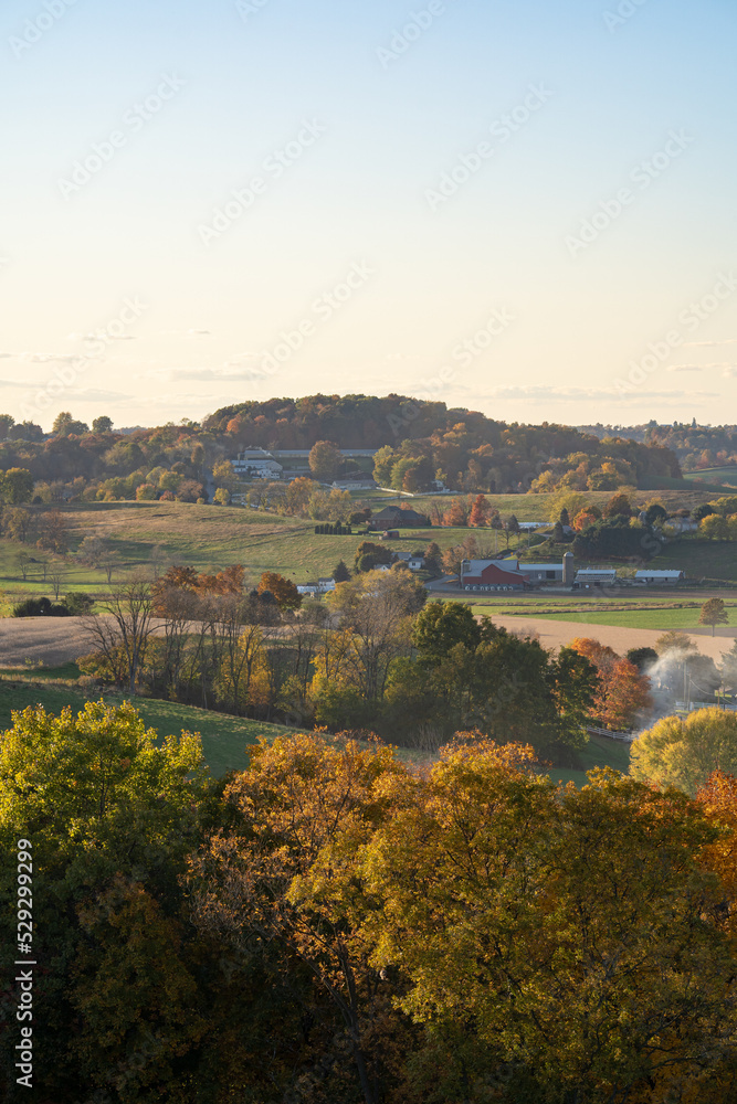 Wooded hills and fields of the Amish country farmland in Holmes County, Ohio, in the late afternoon sunlight in the summer