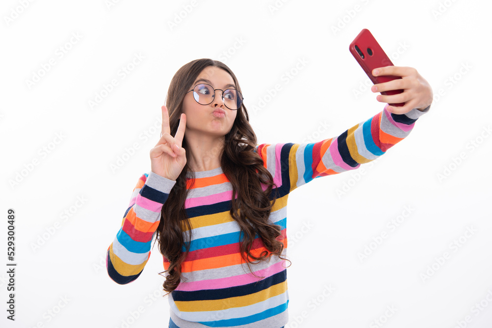 Kids selfie. Funny face. Teenager child girl holding smartphone. Hipster girl with cell phone. Kid hold mobile phone texting in online social networks.