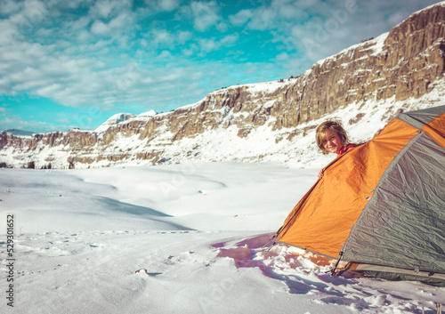 Portrait of smiling woman peeking through tent at Grand Teton National Park during winter