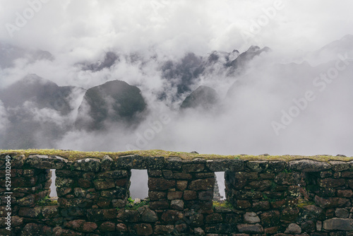 High angle view fortified walls against mountains at machu picchu during foggy weather photo