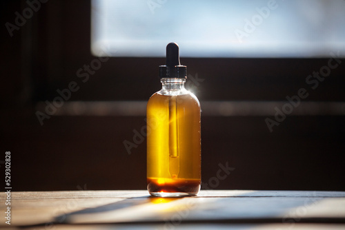 Close-up of oil bottle on wooden table at home photo