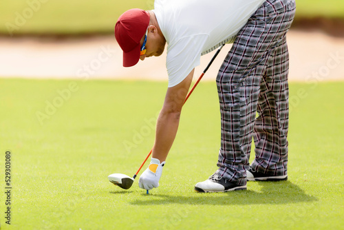Man holding tee while playing at golf course