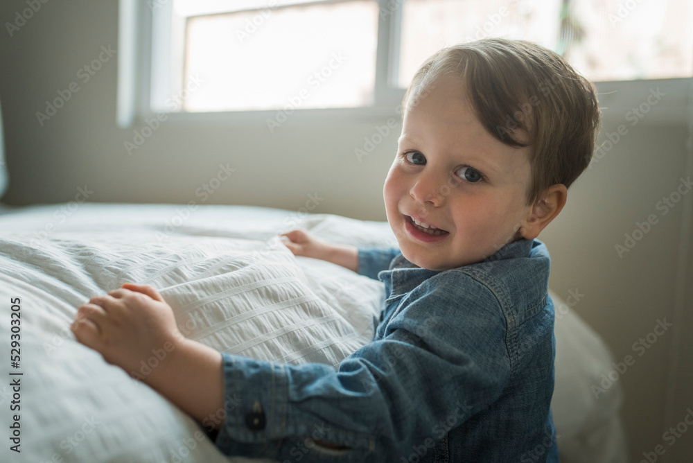 Side view portrait of cute boy smiling in bedroom Side view portrait of cute boy smiling in bedroom