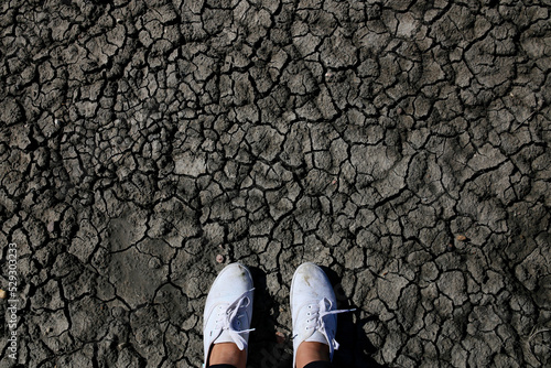 Low section of woman standing cracked land photo