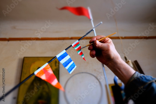 Cropped hand of man coloring bunting flags at workshop photo