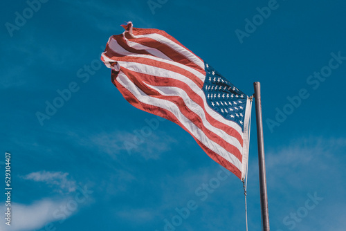 Low angle view of American Flag against blue sky photo