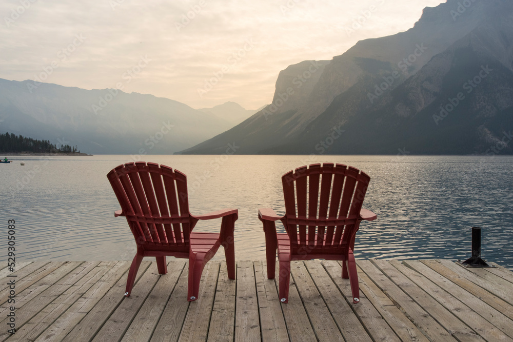 Chairs on jetty over Lake Minnewanka against mountains at Banff National Park Chairs on jetty over Lake Minnewanka against mountains at Banff National Park