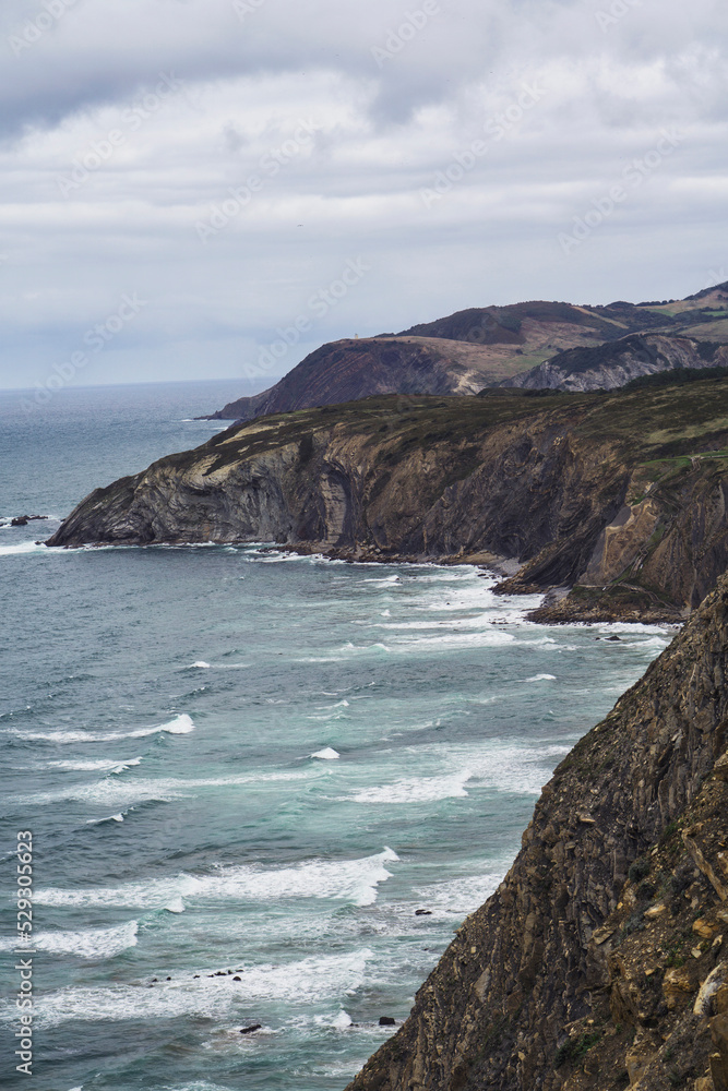 View of sea by mountains against sky View of sea by mountains against sky