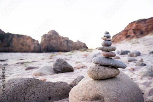 Stack of pebbles at beach against clear sky photo