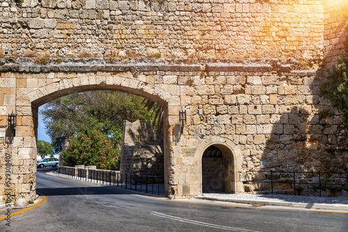 Fototapeta Naklejka Na Ścianę i Meble -  Medieval arched street in the old town of Rhodes, Greece. Rhodes old town in Rhodes island in Greece. Historical streets of old town Rhodes with flowers in Rhodes, Dodecanese, Greece