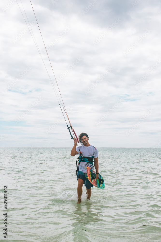 Portrait of man kitesurfing on sea against cloudy sky Portrait of man kitesurfing on sea against cloudy sky