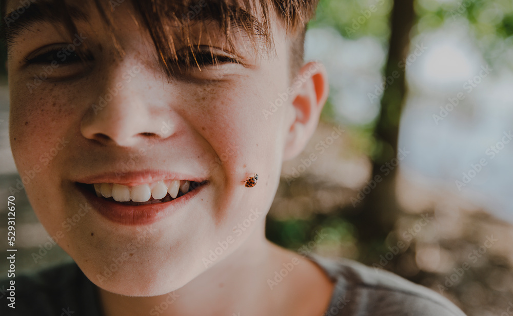 © Cavan Images - Close-up portrait of happy boy with insect on face © Cavan Images - Close-up portrait of happy boy with insect on face