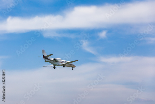 Landing airplane. Landscape with passenger airplane is flying in the blue sky with clouds. Passenger airliner. Business trip. Commercial aircraft. Passenger airplane flying and getting ready to land.