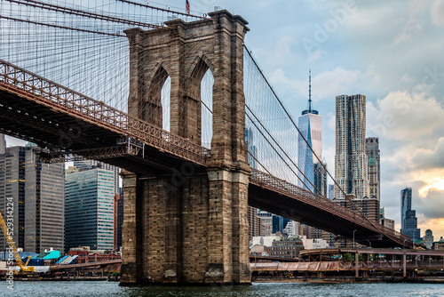 Low angle view of Brooklyn Bridge over East River against modern buildings in city