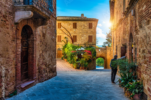 Cozy street decorated with colorful flowers, Pienza, Tuscany, Italy, Europe. Narrow street in the charming town of Pienza in Tuscany. Beautiful streets of the small and historic village Pienza, Italy