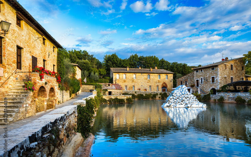 Fototapeta premium Thermal bath town of Bagno Vignoni, Italy during sunrise. Old thermal baths in the medieval village Bagno Vignoni, Tuscany, Italy. Medieval thermal baths in village Bagno Vignoni, Tuscany, Italy