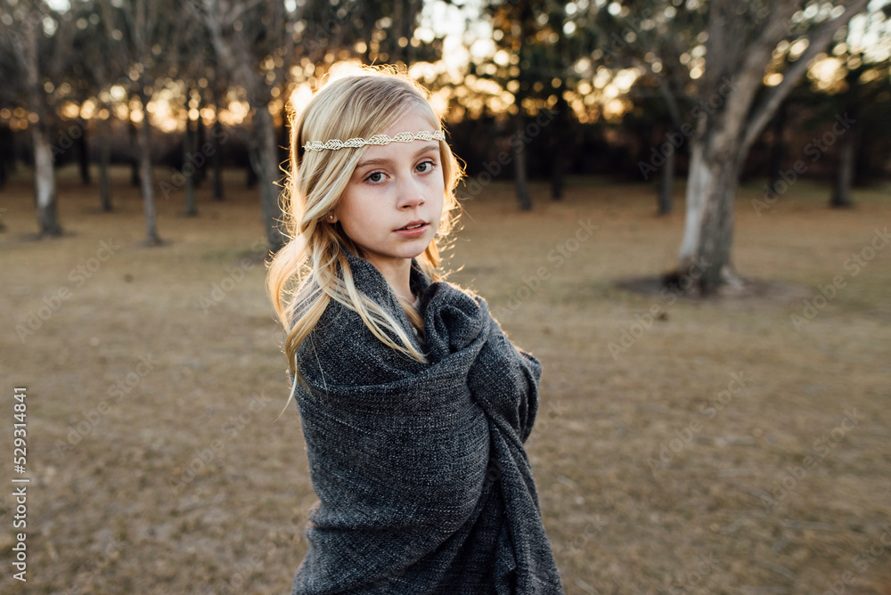 Portrait of cute girl wrapped in blanket standing on field during sunset Portrait of cute girl wrapped in blanket standing on field during sunset